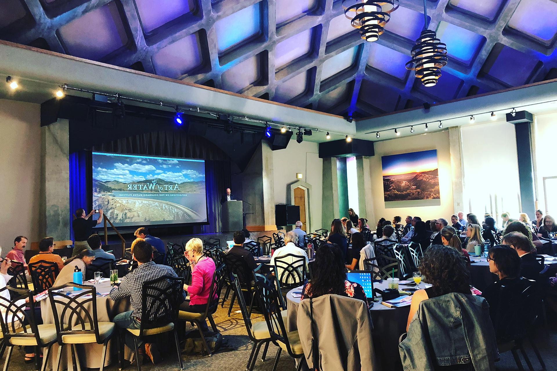 Wide shot of a conference with someone presenting