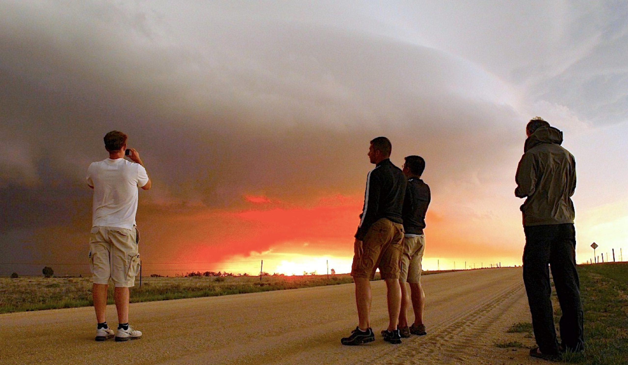 Students and faculty photographing a sunset