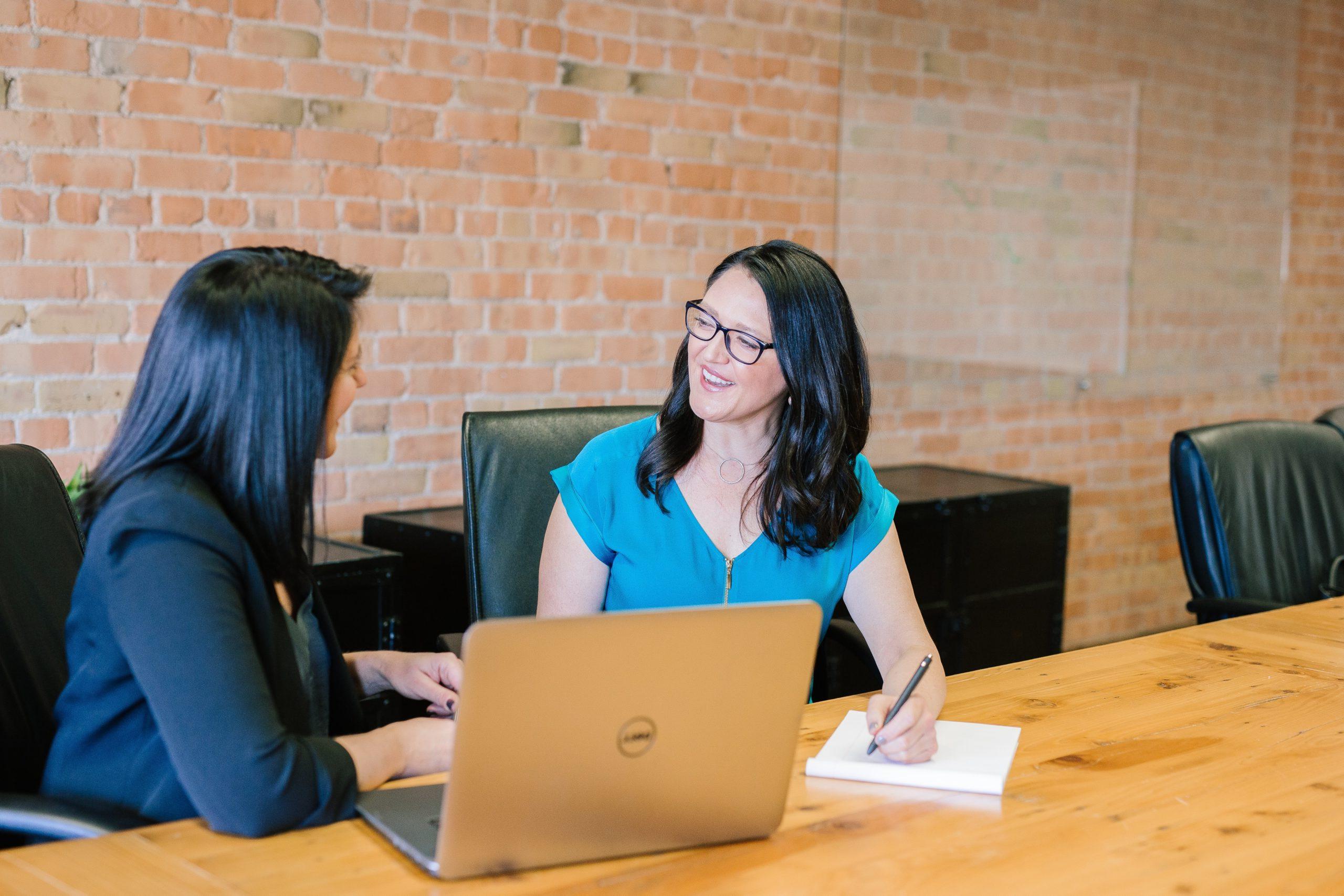 Two people sitting at a table talking to each other