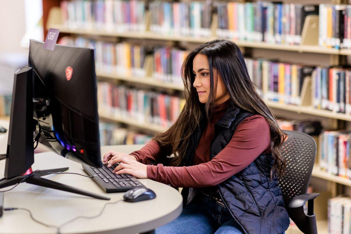 Student working on computer in the library